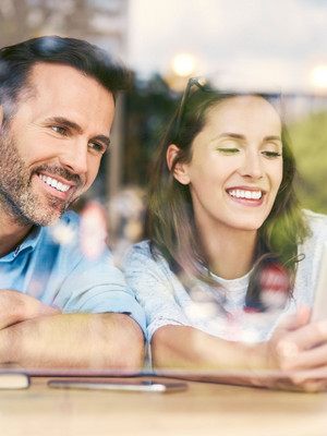 Un jeune couple consulte des offres immobilières sur une tablette