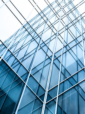 Verglastes Bürogebäude mit Hochhaus im Hintergrund