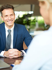 Un homme en costume sourit à une cliente