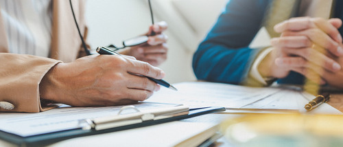 Zwei Männer betrachten Dokumente auf Tisch