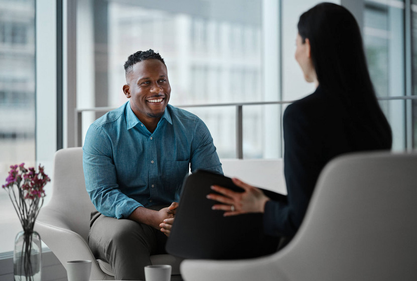 Agent immobilier dos à la caméra parlant à un client sur un salon