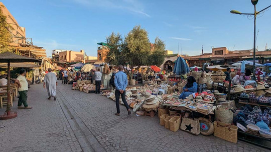 Markt mit vielen verschiedenen Waren und ein Mann der an den Waren vorbeiläuft