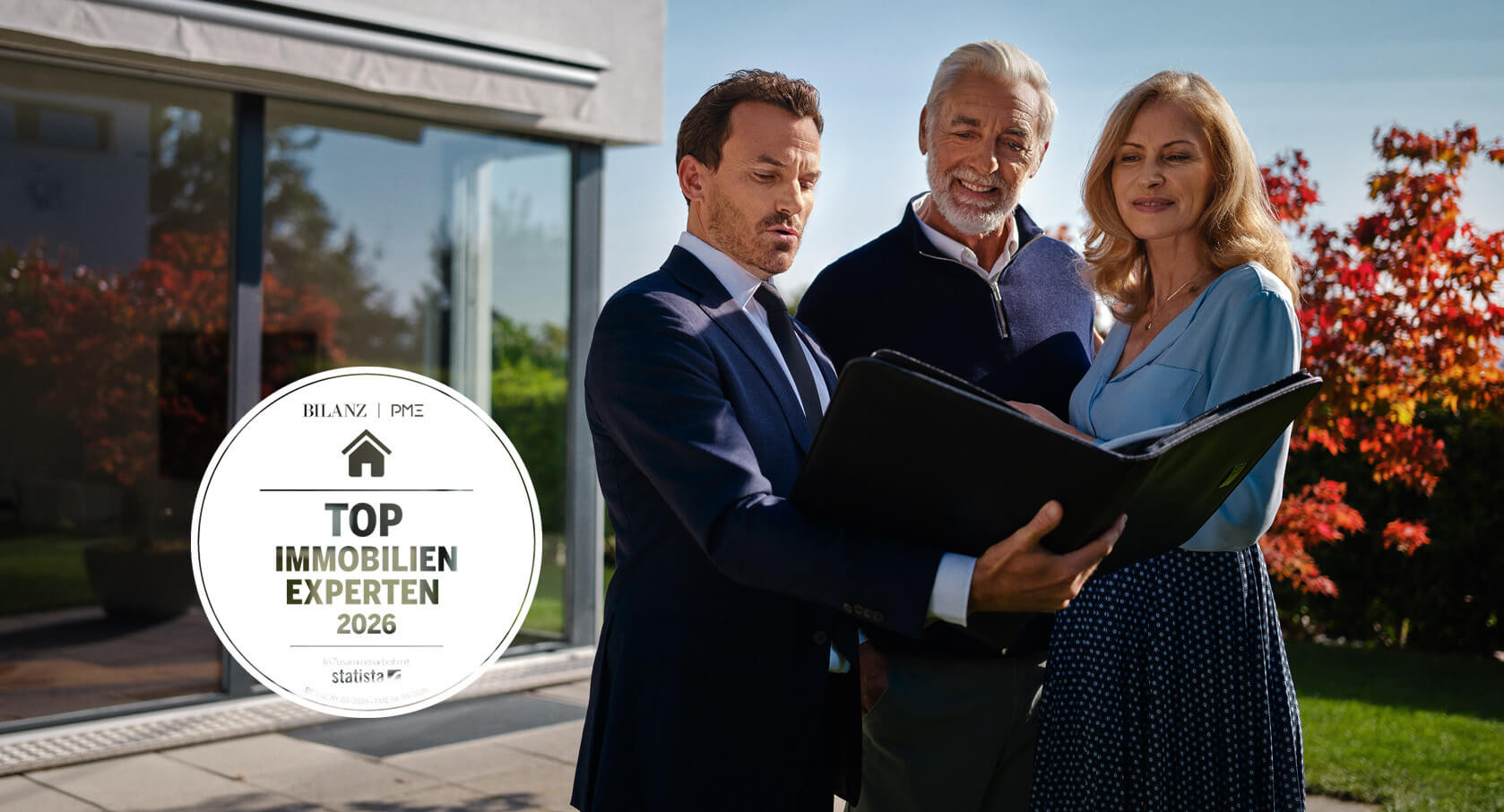 Glückliches Ehepaar steht vor schönem Haus und schaut sich verliebt an