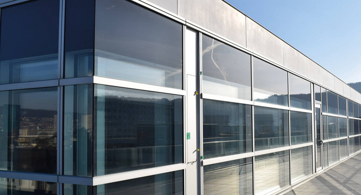Verglastes Bürogebäude mit Logo an der Fassade