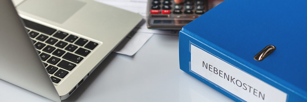 Mann tippt auf Taschenrechner neben Ordner mit Nebenkosten
