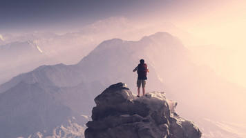 Un homme se tient debout sur une montagne avec un sac à dos