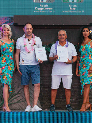 Männer halten Urkunde auf Foto mit Hostessen im Hawaii Kleid
