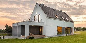 Einfamilienhaus im Grünen bei Sonnenaufgang
