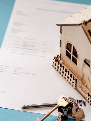 Modello di casa con documenti e chiavi