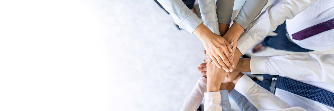 Hände berühren sich in der Mitte und formen einen Kreis, um Teamwork zu symbolisieren