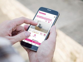 Eine Kamera auf Stativ steht in einem gemütlichen Wohnzimmer