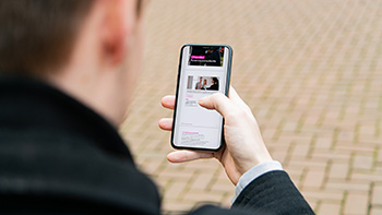 L'homme est au téléphone portable et se tient dehors avec un manteau