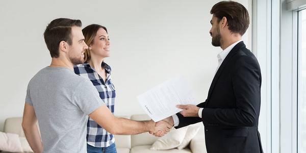 Immobilienmakler und Paar in Wohnung