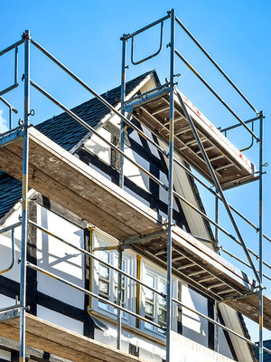 Einfamilienhaus mit Fassadengerüst und blauem Himmel