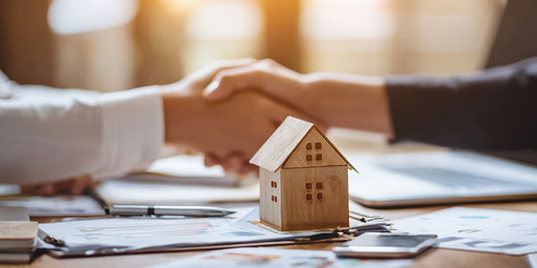 Modellhaus auf Tisch mit Dokumenten