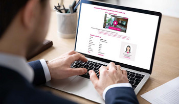 Mann sitzt vor einem Laptop und sieht sich ein Immobilieninserat an